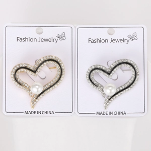 Détail de broches en cœur or et argent avec strass et perles élégantes de luxe