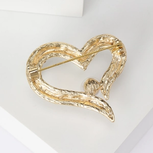 Broche cœur dorée élégante avec finition texturée et vue sur l'épingle de sûreté