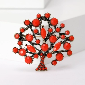 Vintage money tree brooch with faceted red gemstones and antique metal finish on white backdrop