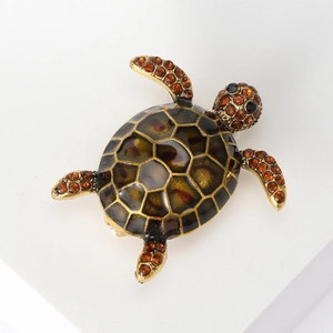 Detailed macro view of vintage turtle brooch with amber rhinestones and enamel shell