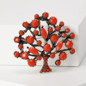 Macro shot of retro style tree of life brooch with vibrant red beads and antique metal finish
