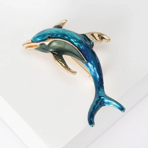 Elegant gold-plated dolphin brooch with deep blue enamel inlay on a white background