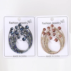 Detail view of crystal brooches with sparkling blue and pink stones on elegant metal settings