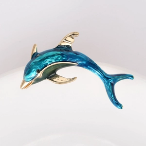 Detailed close-up of blue gradient enamel dolphin brooch with polished gold-tone edges