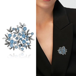 Elegant silver branch brooch with sky blue berries and crystals shown on model