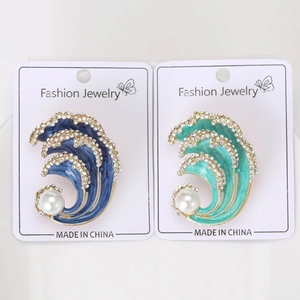 Detailed view of wave-shaped brooches with blue enamel, rhinestones, and large pearls