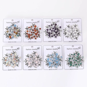 Close-up of alloy tree brooches with colorful faux pearls and stones in eight color variants