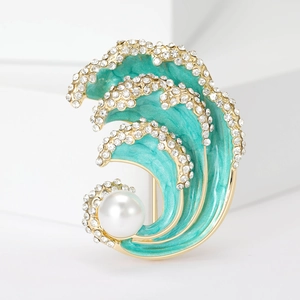 Detail of blue wave brooch with gold plating, sparkling rhinestones, and a large white pearl