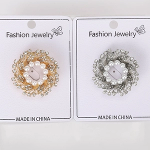 Close-up of gold and silver flower wreath brooches with pearls and rhinestones