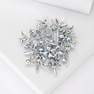 Elegant floral berry brooch with blue pearls and silver metal leaves in studio white background