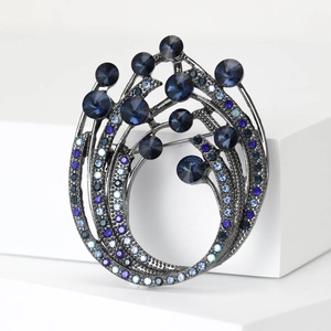 Detailed close-up of a circular rhinestone brooch with deep blue and crystal stones