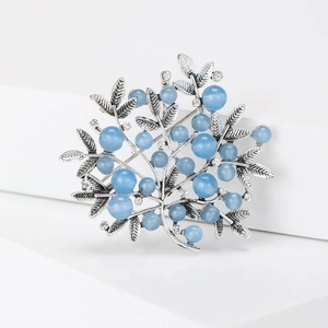 Detailed view of vintage silver tree brooch with light blue pearls and rhinestones