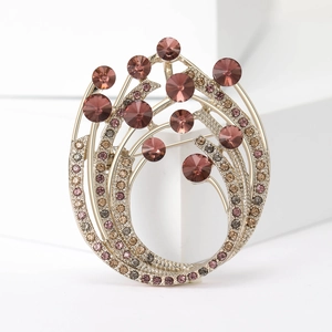Detailed view of an artistic gold brooch with purple gemstones and micro-pave crystals