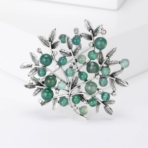 Elegant silver tree branch brooch with green pearls and sparkling crystal accents