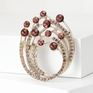 Close-up of elegant purple crystal brooch with rhinestones on a white geometric base