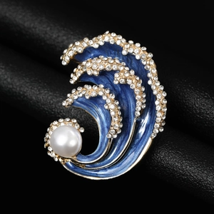 Close-up detail of waves brooch with blue enamel inlay and sparkling white rhinestones