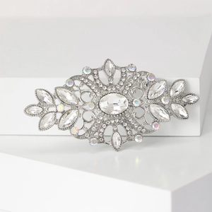 Vintage silver floral brooch with crystal rhinestones on minimalist white display