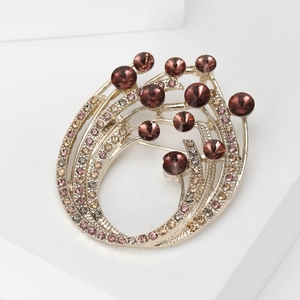 Detailed view of vintage flowing rhinestone brooch with multi-colored crystals on white stand