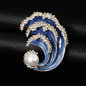 Detail of blue enamel wave brooch with sparkling rhinestones and a white pearl accent
