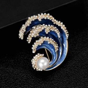Macro detail of blue wave brooch with enamel, sparkling crystals and a white pearl