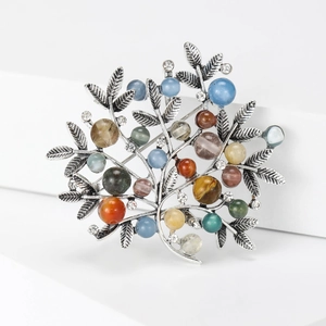 Detail of vintage silver tree brooch featuring colorful beads and crystal accents