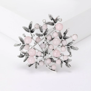 Close-up of tree-shaped brooch with silver alloy leaves and pink pearl accents
