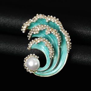 Detailed shot of wave brooch with turquoise enamel, pearls and crystals on black background