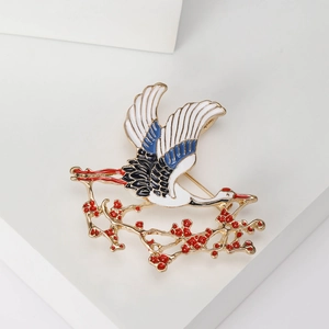 Elegant crane brooch with plum blossom accents in traditional Chinese style on white stand