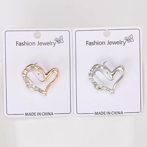 Dettaglio di spille a cuore oro e argento con cristalli su scheda di esposizione
