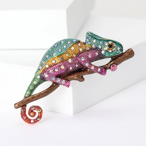 Detailed macro view of a colorful rhinestone chameleon brooch on a geometric block
