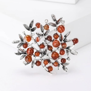 Detailed macro of a vintage berry tree brooch with brown beads and sparkling rhinestones