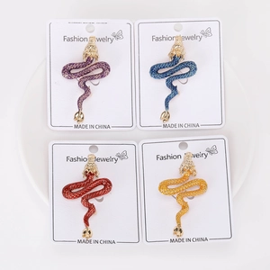 Detailed view of four colorful enamel dragon brooches on display cards for suits