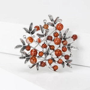 Detail of vintage branch brooch with reddish-brown beads and sparkling crystals