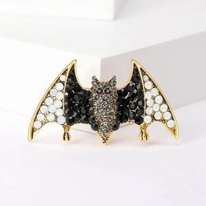 Detail of bat brooch with black and white crystals on golden alloy base for Halloween