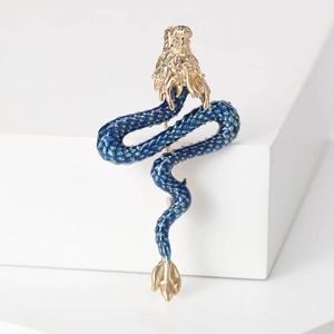 Detailed view of enamel Chinese dragon brooch with gold-plated scales and blue body