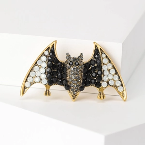 Close-up of gothic bat brooch with black and grey rhinestones on a golden base