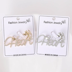 Detail of gold and silver letter heart brooches with rhinestones and cupid motif