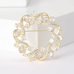 Macro detail of elegant golden olive branch wreath brooch with cubic zirconia stones