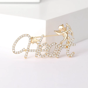 Elegant gold-tone Cupid Heart brooch with sparkling rhinestones on a white podium