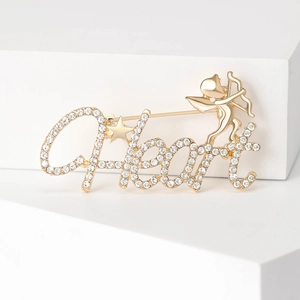 Detail of gold Heart brooch with sparkling rhinestones and Cupid figure on a white pedestal