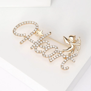 Detail of a gold-tone Lucky Cupid brooch featuring sparkling rhinestones and a polished finish