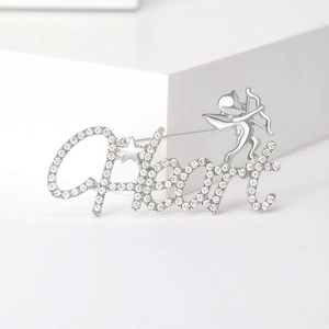 Detailed view of silver Cupid brooch featuring Heart script and shimmering crystals