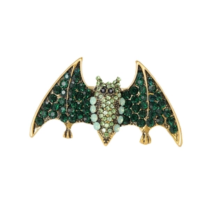 Vintage gold bat brooch with emerald green crystals and sparkling gemstone wings