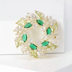 Détail de la broche couronne de blé avec émeraudes et zircons sur une base dorée