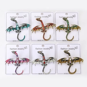 Macro view showing six colors of dragon enamel pins with rhinestones on display cards