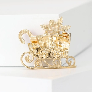 Rear view of a Christmas sleigh brooch showing the secure pin and gold alloy structure