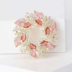Détail macro d'une élégante broche couronne de blé en zircon avec pierres roses