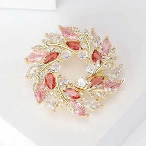 Détail macro d'une élégante broche couronne dorée avec cristaux roses et rouges