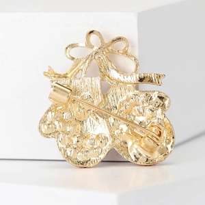 Golden Christmas gloves brooch back view showing safety pin and textured finish