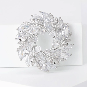 Détail macro d'une broche couronne en zircon argenté avec pierres marquises